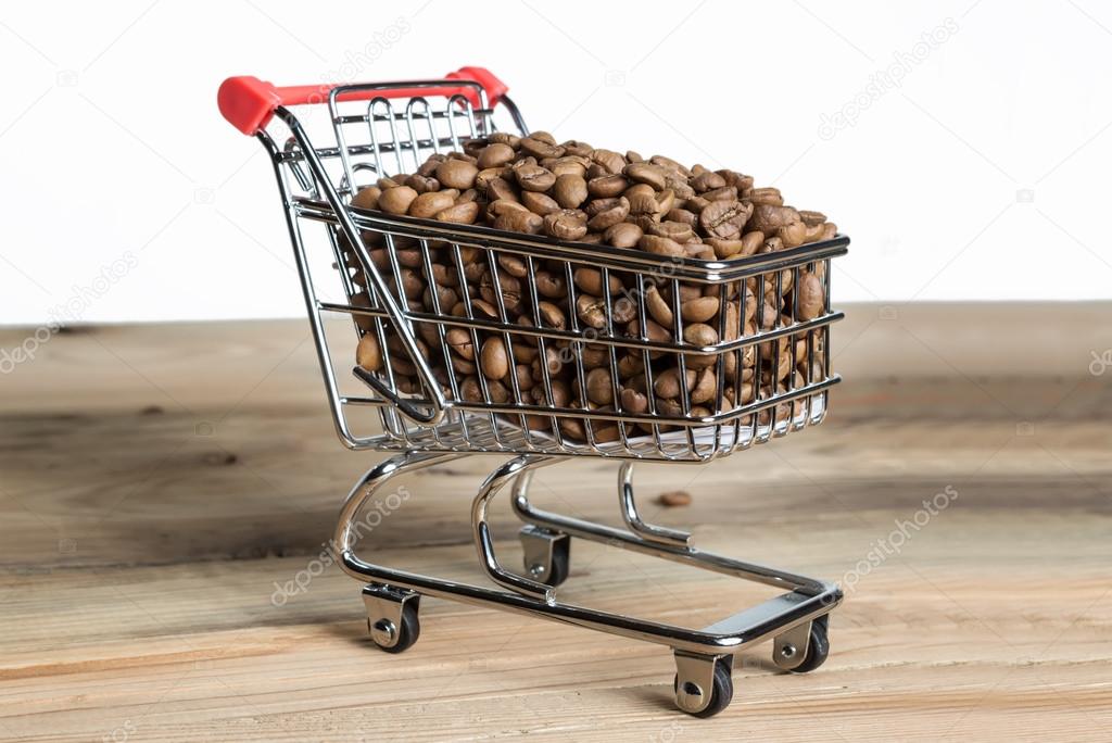 The shopping cart with coffee beans on wooden table