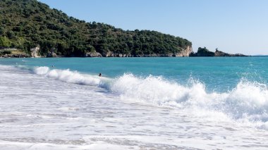 Beyaz kum plaj ve mavi gökyüzü. Plaj arka planda Yunanistan
