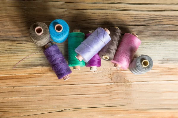 Spools of thread on wooden  background. Old sewing accessories. — Stock Photo, Image