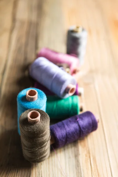 Bobine di filo su sfondo di legno. Vecchi accessori per cucire . — Foto Stock