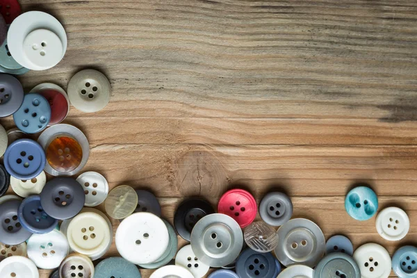 Gekleurde knoppen op de houten plank, kleurrijke knoppen, op oude houten — Stockfoto