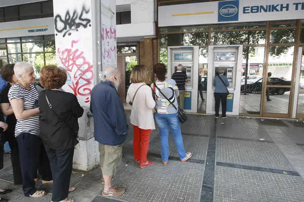 People stand in a queue to use the ATMs of a bank — Stock Photo, Image