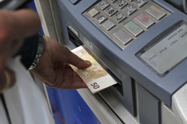 İnsanlar bir bankanın ATM kullanmak için bir sıra stand