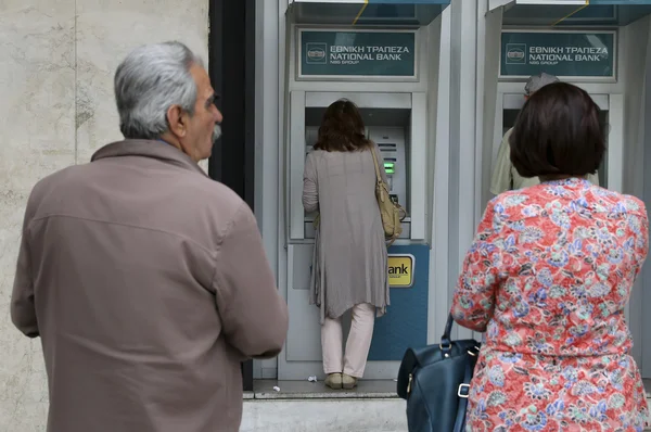 Orang-orang berdiri dalam antrian untuk menggunakan ATM bank — Stok Foto