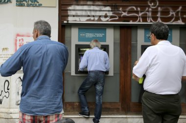 İnsanlar bir bankanın ATM kullanmak için bir sıra stand