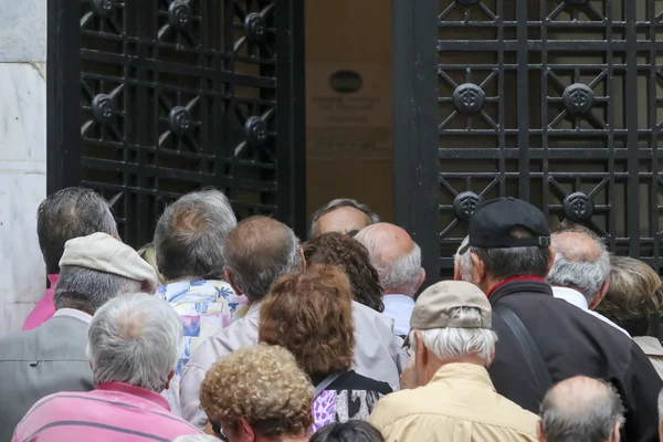 Los pensionistas hacen cola fuera de una sucursal del Banco Nacional como bancos solamente op —  Fotos de Stock