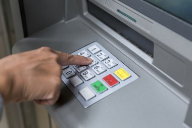 People stand in a queue to use the ATMs of a bank. Person receiv