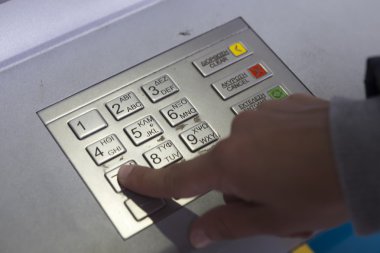 People stand in a queue to use the ATMs of a bank. Person receiv