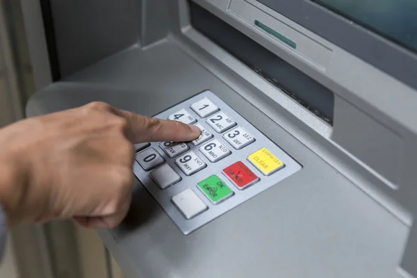 People stand in a queue to use the ATMs of a bank. Person receiv — Stockfoto