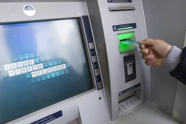 People stand in a queue to use the ATMs of a bank. Person receiv — Stockfoto