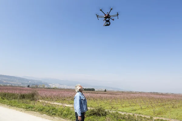 Uomo guarda DJI S900 drone in volo con un sony montato A7 Modifica — Foto Stock
