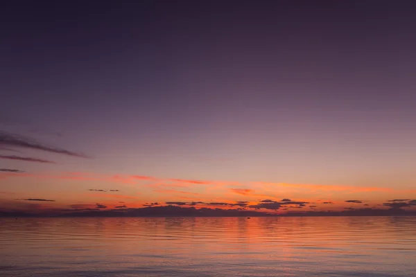 Beau coucher de soleil avec des nuages dans le ciel sur l'océan — Photo