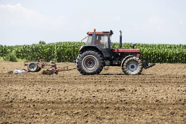 Un tractor trabajando plantando trigo en los fértiles campos de cultivo de G —  Fotos de Stock