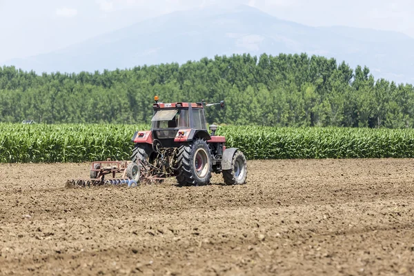 Un tracteur travaillant la plantation de blé dans les champs fertiles de G — Photo