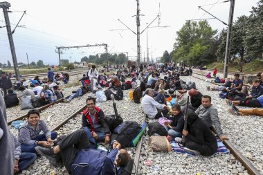 Hundreds of immigrants are in a wait at the border between Greec clipart