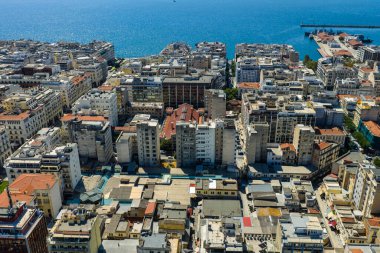 Selanik, Aristo Meydanı 'ndan denize doğru uzanır. Neoklasik zarafet, kıyı ritmiyle buluşur. Şehir yumuşak ve bulutlu bir gökyüzü altında tepelere doğru uzanır..