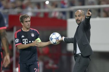 Philipp Lahm (L) taking the ball from Coach Josep Guardiola (R)