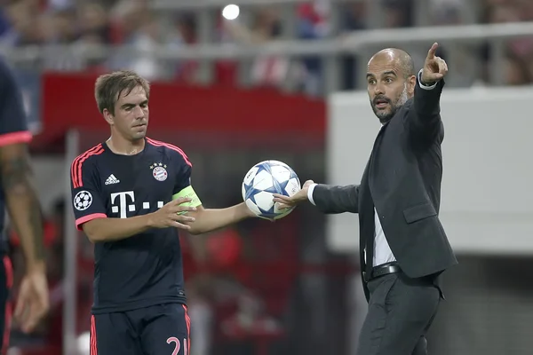 Philipp Lahm (l) nimmt Trainer Josep Guardiola (r) den Ball ab.) — Stockfoto