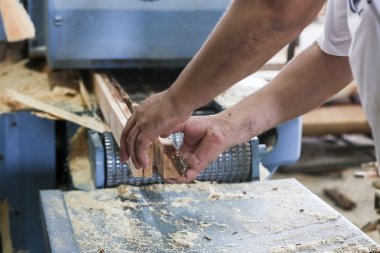 Yunanistan'da bir ağaç işleme fabrikası'nda ahşap bir parça kesip esnaf