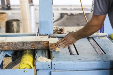 Craftsmen cut a piece of wood at a woodworking factory in Greece clipart