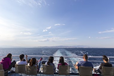 Santorini Isla bir gemi başlığa güvertede oturan turist