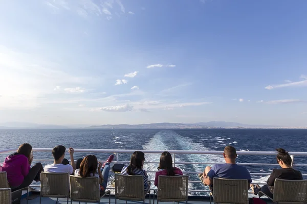 Touristes assis sur le pont d'un navire se dirigeant vers l'île de Santorin — Photo