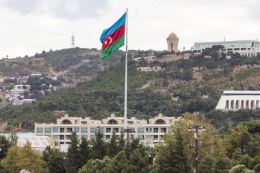 Azerbaycan bayrağı şehrin önünde rüzgarda sallayarak