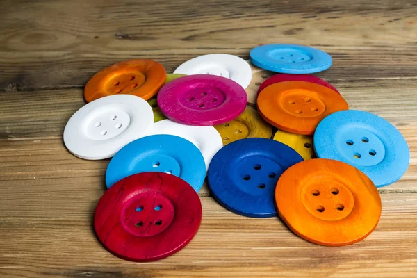Ahşap masa, eski ahşap renkli düğmeler üzerinde renkli düğmeler — Stok fotoğraf