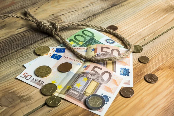 Hangman's strop met geld op bruin houten achtergrond — Stockfoto