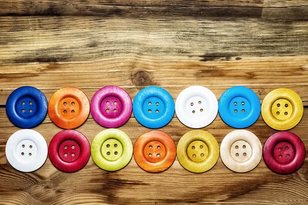 Colored buttons on wooden board, Colorful buttons, on old wooden — Stock Photo, Image