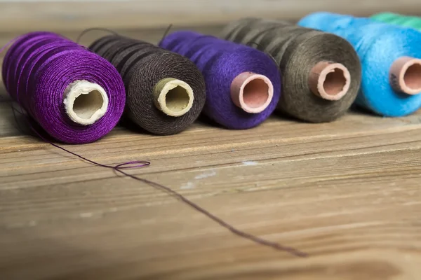 Spools of thread on wooden background. Old sewing accessories. c — Stock Photo, Image