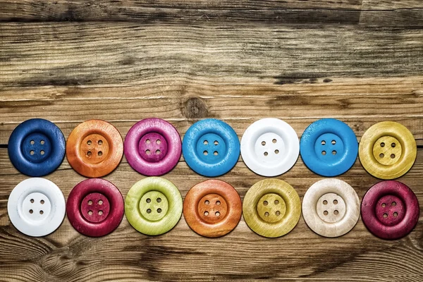 Colored buttons on wooden board, Colorful buttons, on old wooden — Stock Photo, Image