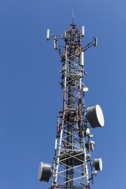 Mavi gökyüzüne karşı antenli iletişim kulesi