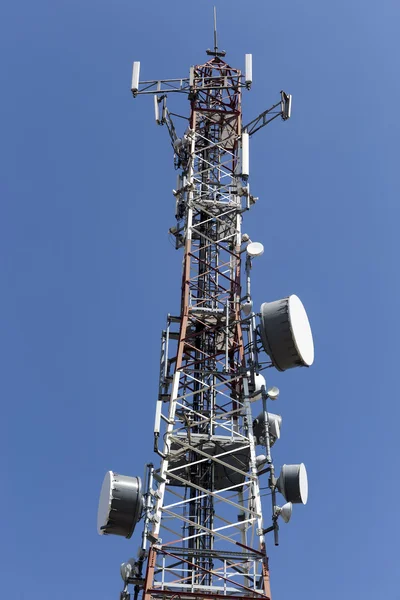 Torre de comunicações com antenas contra o céu azul — Fotografia de Stock