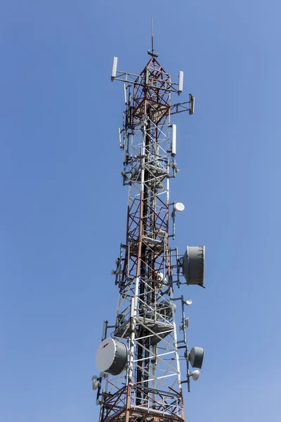 Wieża komunikacyjna z antenami przeciwko błękitnemu niebu — Zdjęcie stockowe