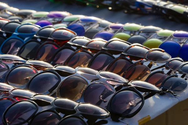 Diferentes gafas de sol modernas se acercan a la mesa — Foto de Stock