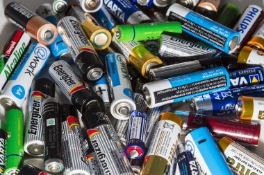 Different types of used batteries ready for recycling lying in a clipart