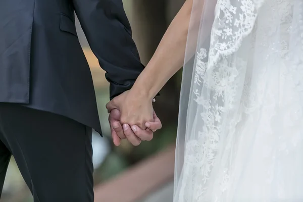 Closeup of a bride and groom holding hands — Stock Photo, Image