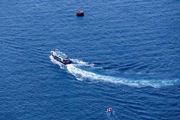 Yacht navigates into beautiful blue water near Santorini island, — Stock Photo, Image