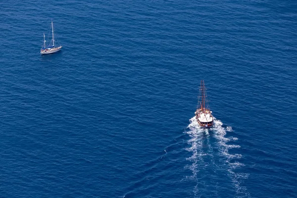 Yacht navigates into beautiful blue water near Santorini island, — Stock Photo, Image