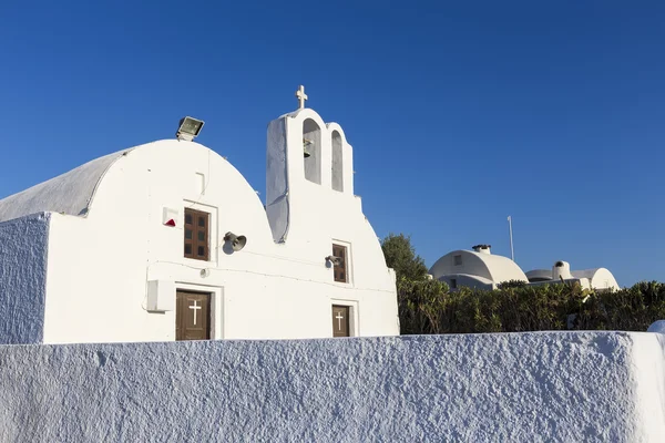 Arco tradizionale greco chiesa bianca con croce e campane in vill — Foto Stock