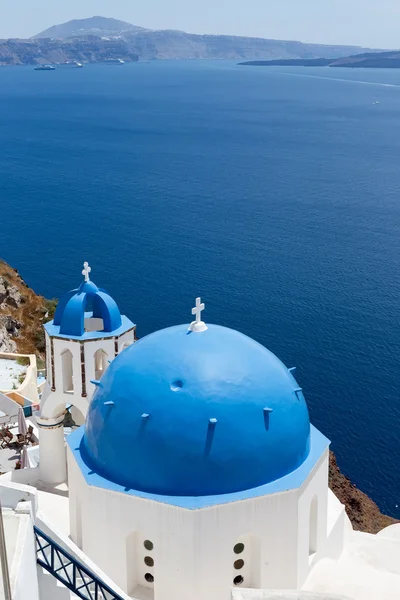 Kyrkor med blåa kupoler på Caldera på Oia på den grekiska ön — Stockfoto