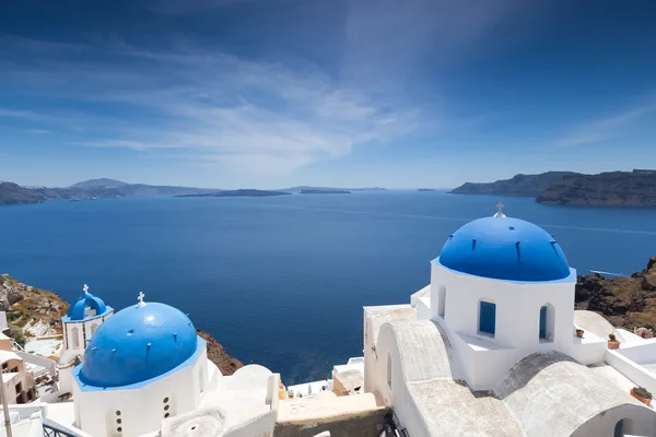 Kyrkor med blåa kupoler på Caldera på Oia på den grekiska ön — Stockfoto