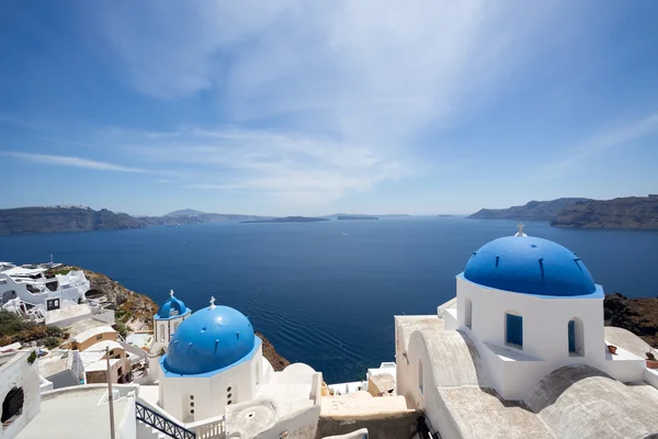 Blaue Kuppelkirchen auf der Caldera von Oia auf der griechischen Insel — Stockfoto