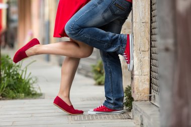 Young couple kissing outdoor. Male and female legs  clipart