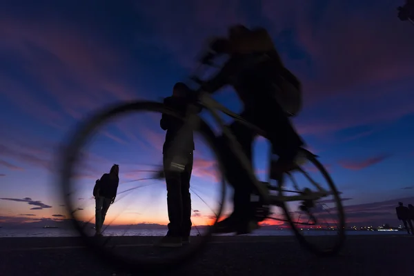 Die Silhouetten machen Aktivitäten am Strand bei Sonnenuntergang — Stockfoto