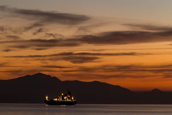 Pescador en el barco sobre el atardecer dramático, macho en barco, beau — Foto de Stock