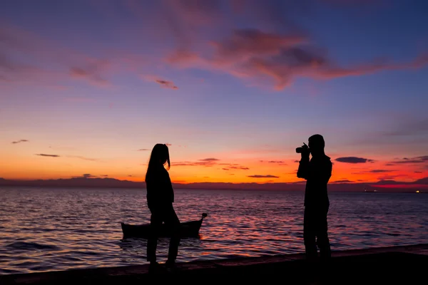 Les Silhouettes font des activités sur la plage au coucher du soleil — Photo