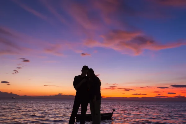 Les Silhouettes font des activités sur la plage au coucher du soleil — Photo