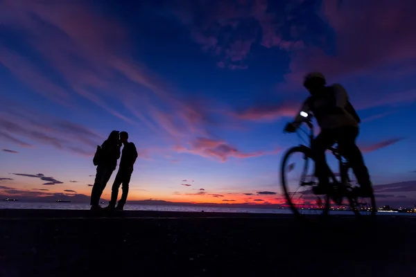 Die Silhouetten machen Aktivitäten am Strand bei Sonnenuntergang — Stockfoto